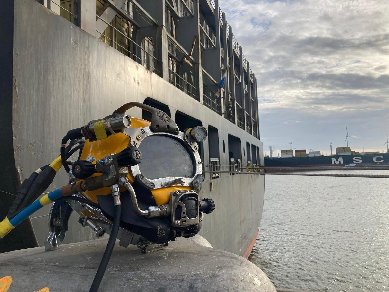 Surface-supplied diving helmet on the quay alongside a container vessel in the Port of Antwerp